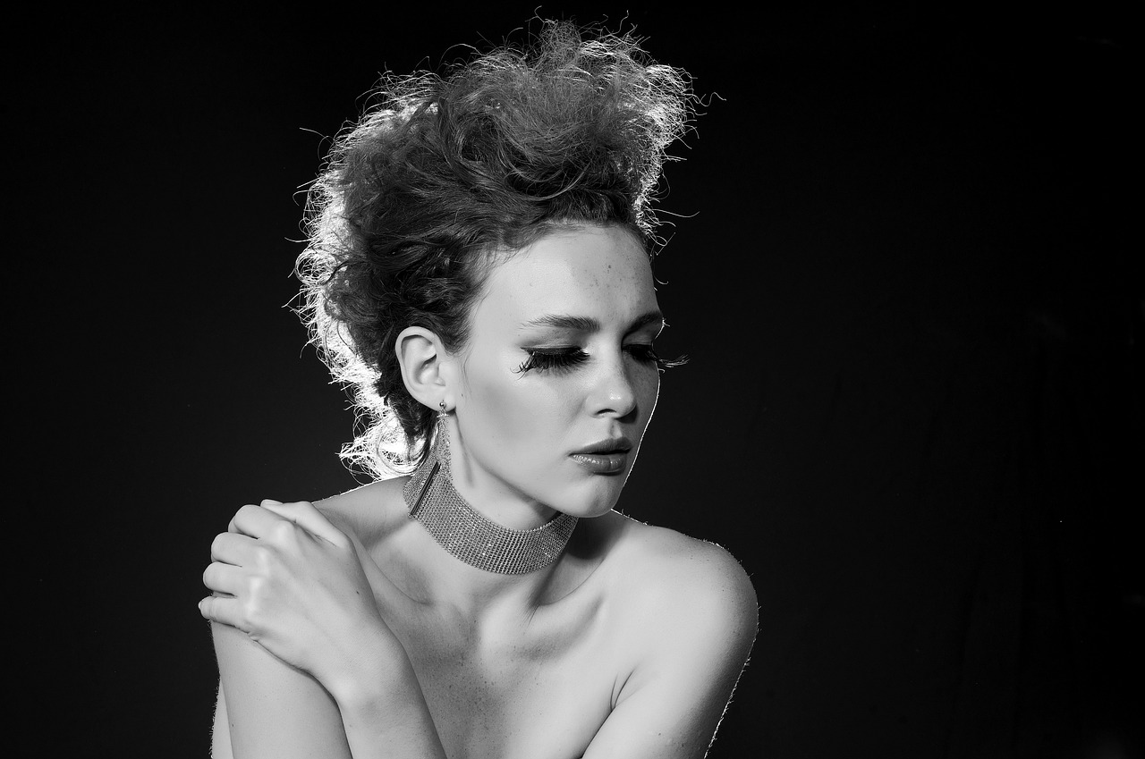 a black and white photo of a beautiful woman, a black and white photo, inspired by Bert Stern, curly messy high bun hairstyle, a redheaded young woman, wearing choker, 7 0 mm dramatic lighting
