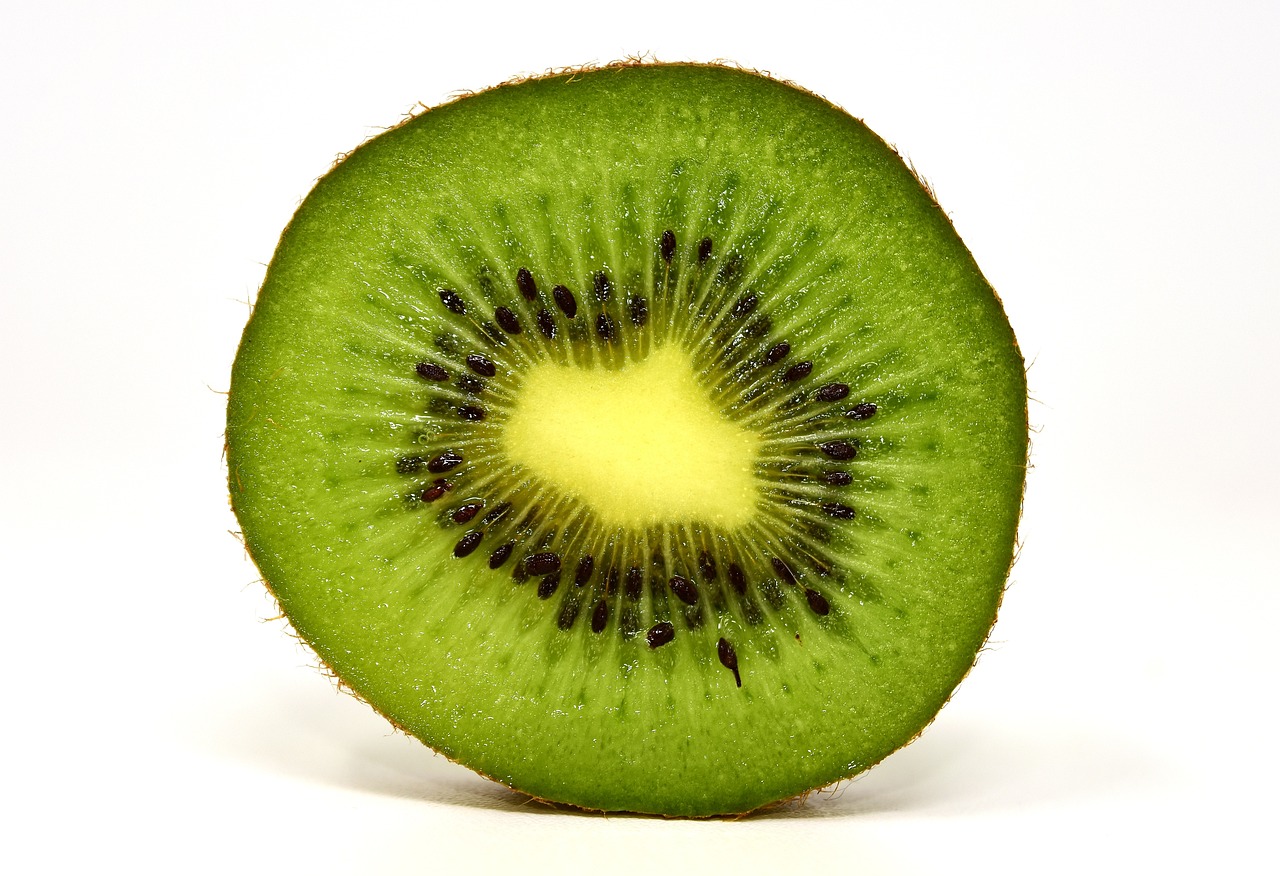 a kiwi cut in half on a white surface, by Gavin Hamilton, hurufiyya, closeup photo, it\'s name is greeny, very sharp photo