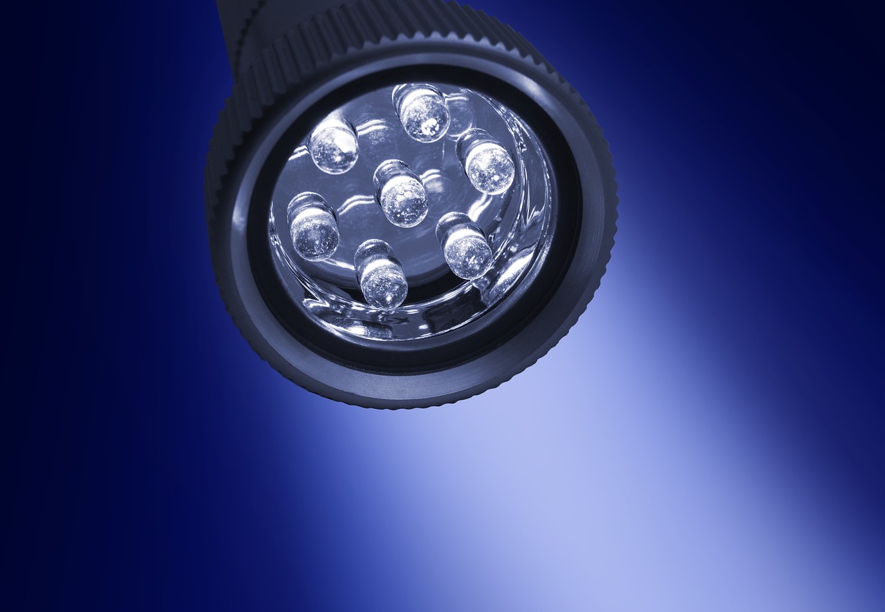 a close up of a flashlight on a blue background, a stock photo, photorealism, high res photo, reflection of led lights, fisheye lens photo, high definition photo
