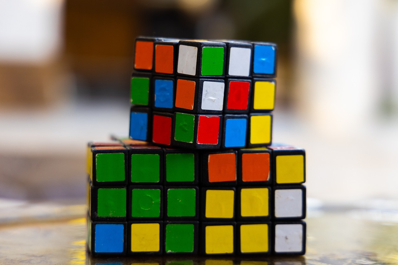two rubik cubes stacked on top of each other, a jigsaw puzzle, inspired by Ernő Rubik, cubo-futurism, close - up bokeh, set photo, colorful details, 70s photo
