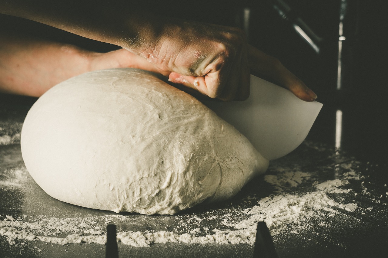a person kneads a ball of dough on a table, a portrait, by Karl Buesgen, unsplash, calzone zone, stock photo, frosting on head and shoulders, 4 0 9 6