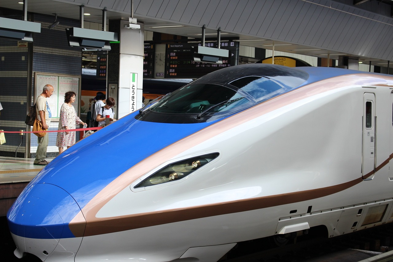 a close up of a train at a train station, flickr, sōsaku hanga, aerodynamic body, with people inside piloting it, stunning high tech, medium head to shoulder shot