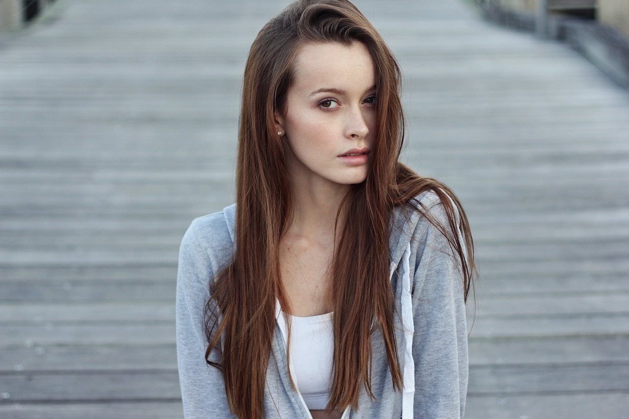 a beautiful young woman standing on top of a wooden walkway, inspired by Ksenia Milicevic, tumblr, with long hair and piercing eyes, gorgeous kacey rohl, on the street, wearing sweatshirt