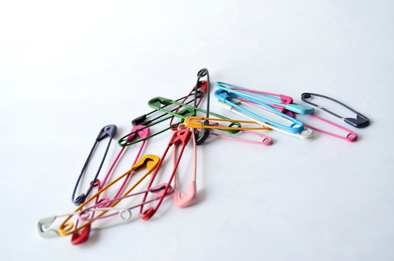 a pile of safety pins sitting on top of a white surface, a pastel, by Eugeniusz Zak, flickr, colorful medical equipment, long view, modern very sharp photo, photo of a beautiful