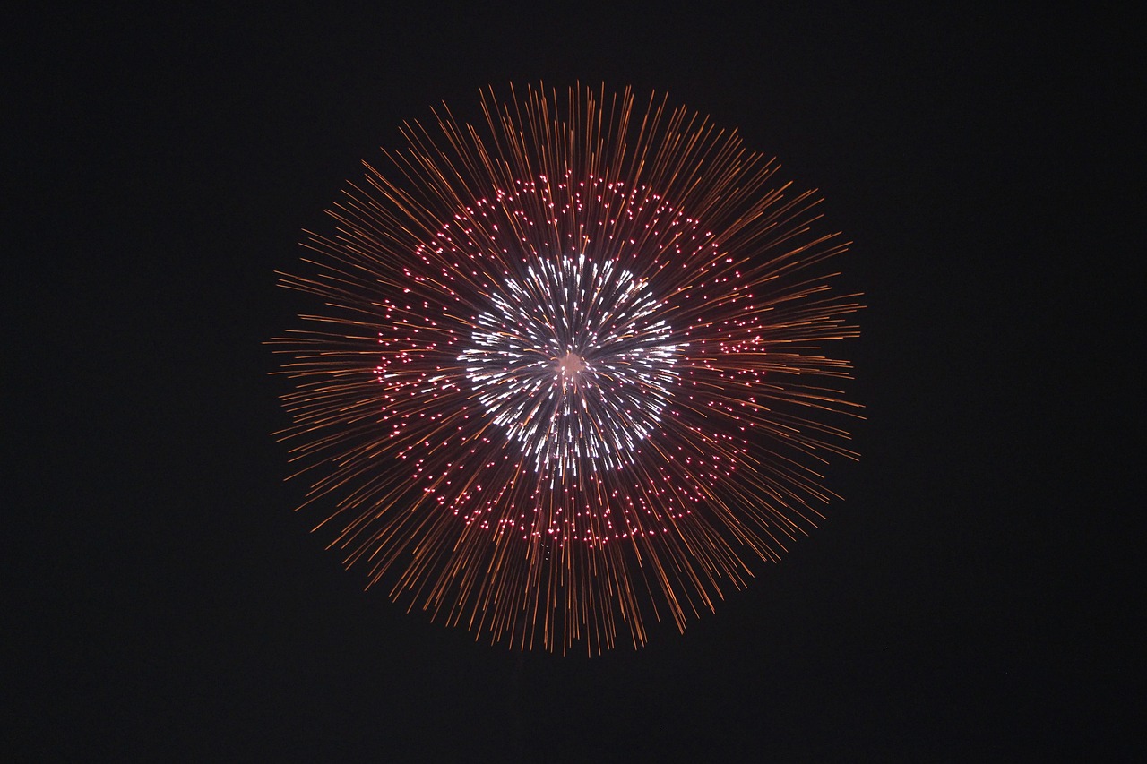 a fireworks is lit up in the night sky, a stipple, hurufiyya, a large sphere of red energy, high res photo, crown of white lasers, low angle photo