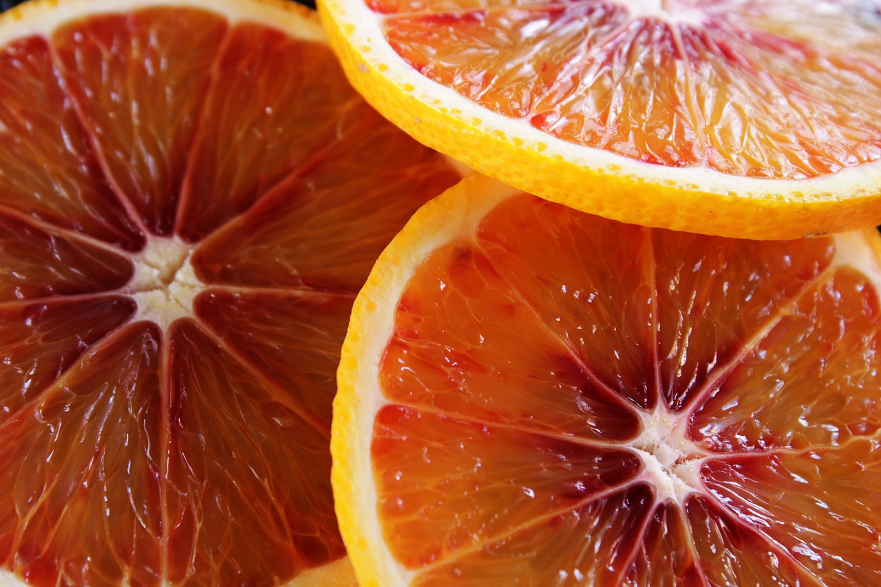 a pile of sliced oranges sitting on top of a table, a screenshot, pexels, process art, thin red veins, colourful close up shot, close-up product photo, red blood