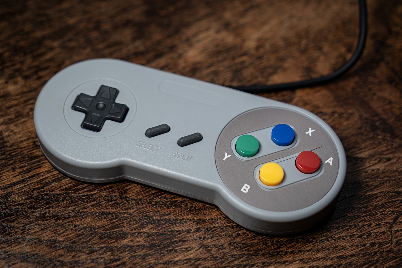 a video game controller sitting on top of a wooden table, inspired by Miyamoto, unsplash, neogeo, silver and muted colors, on a gray background, photograph credit: ap, neck zoomed in