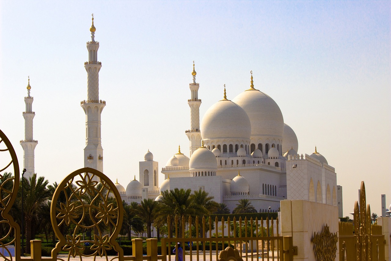 a woman sitting on a bench in front of a large white building, by Sheikh Hamdullah, shutterstock, dau-al-set, black domes and spires, taken in 1 9 9 7, an arab standing watching over, intricate ”