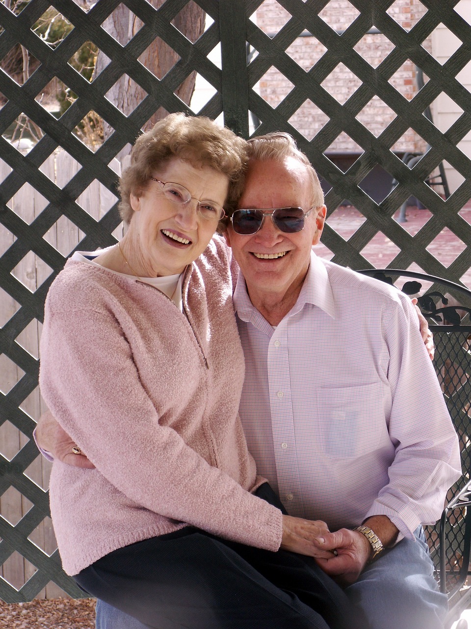 a man and a woman sitting on a bench, a portrait, by Bernie D’Andrea, smiling couple, elderly, las vegas, rose