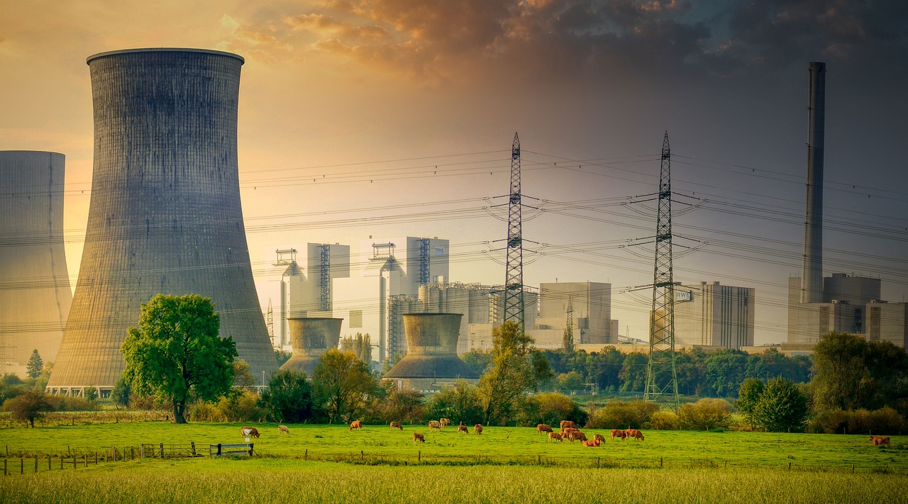 a group of cows grazing in a field in front of a nuclear power plant, a picture, shutterstock, industrial gotham city, mattepainting, industrial pipes, 2 0 2 2 photo