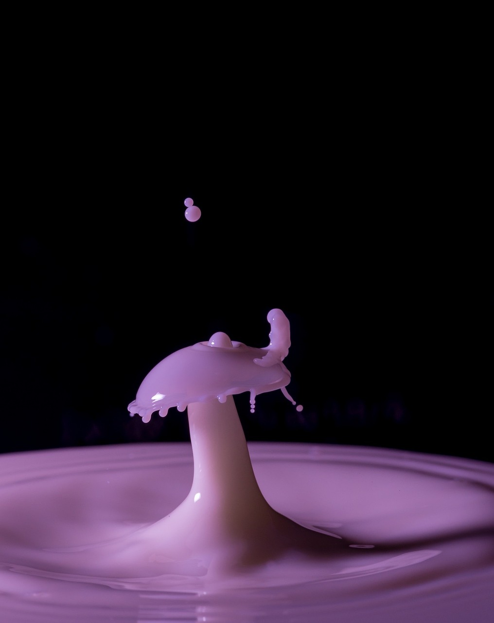a close up of a liquid drop with a black background, by Doug Ohlson, unsplash, digital art, yogurt, purple alien, porcelain forcefield, cake
