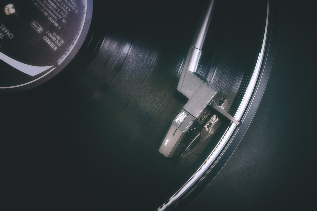 a close up of a record on a table, an album cover, by Jan Kupecký, unsplash, desaturated!, spinning records, background image, jukebox