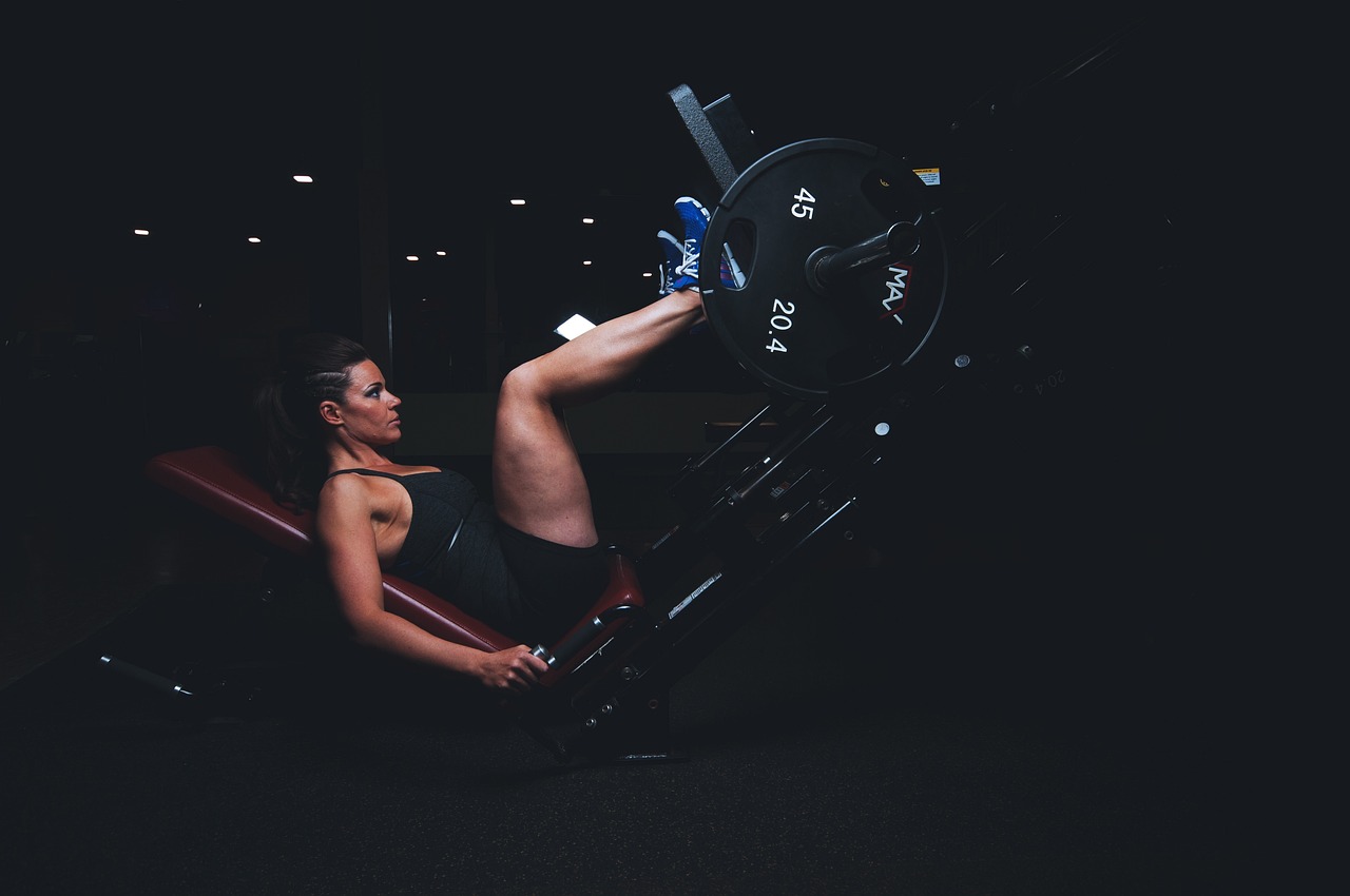 a woman sitting on top of a machine in a gym, a photo, pexels, hard lighting!, no aditional legs!, in an action pose, marketing photo