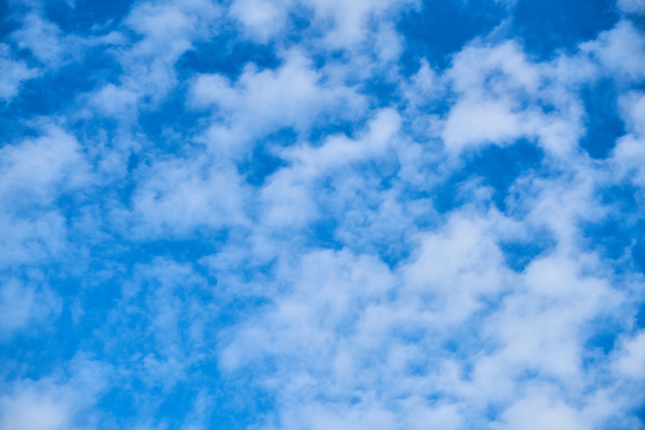 a large jetliner flying through a blue cloudy sky, a stock photo, minimalism, clouds of vivid horse-hair wigs, whorl. clouds, beautiful cloudy deep blue sky, fog background