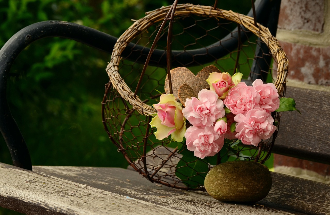 a basket filled with pink flowers sitting on top of a wooden bench, a picture, by Maksimilijan Vanka, pixabay contest winner, wicker art, wallpaper - 1 0 2 4, rose twining, loosely cropped