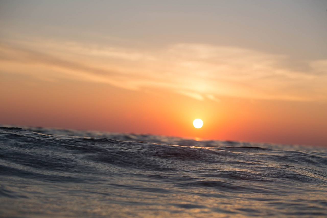 the sun is setting over a body of water, a picture, by Alexander Runciman, pexels, romanticism, pristine rippling oceanic waves, depth of field”, istock, sunset + hdri