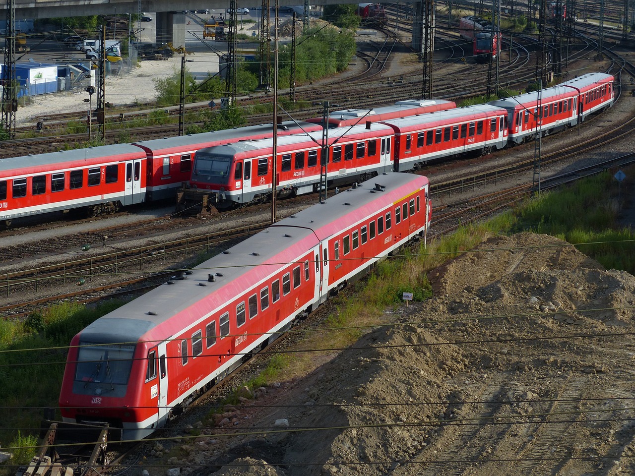 a couple of trains that are on some tracks, by Werner Gutzeit, flickr, red robes, terminal, full daylight, h.r. geiger