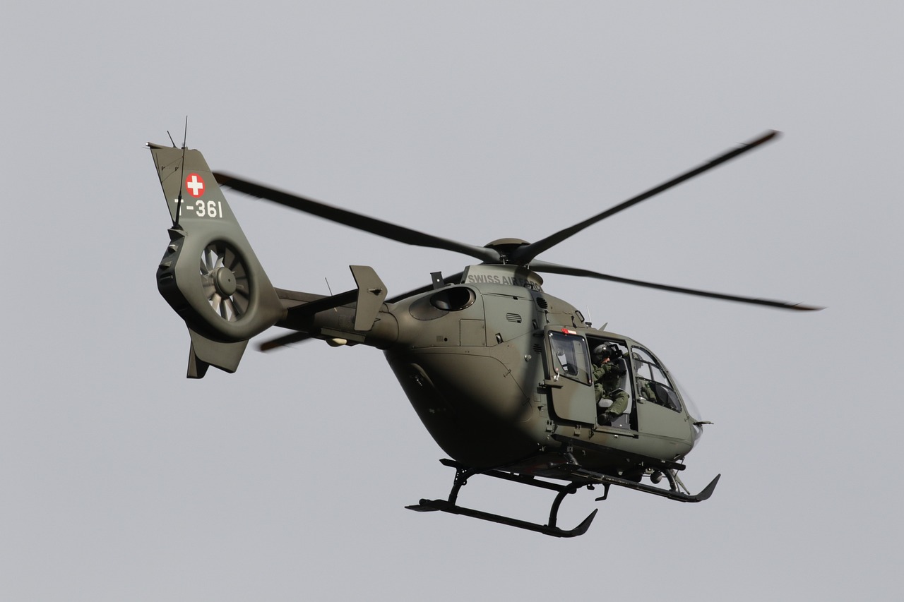 a military helicopter flying through a gray sky, a picture, by József Borsos, hurufiyya, seen from above, seen from the side, olive, swiss