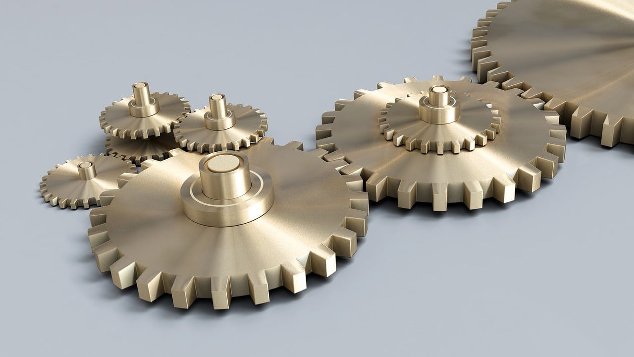 a group of metal gears sitting on top of a table, a digital rendering, precisionism, brass wheels, rotary symmetrical, gilt metal, modeled