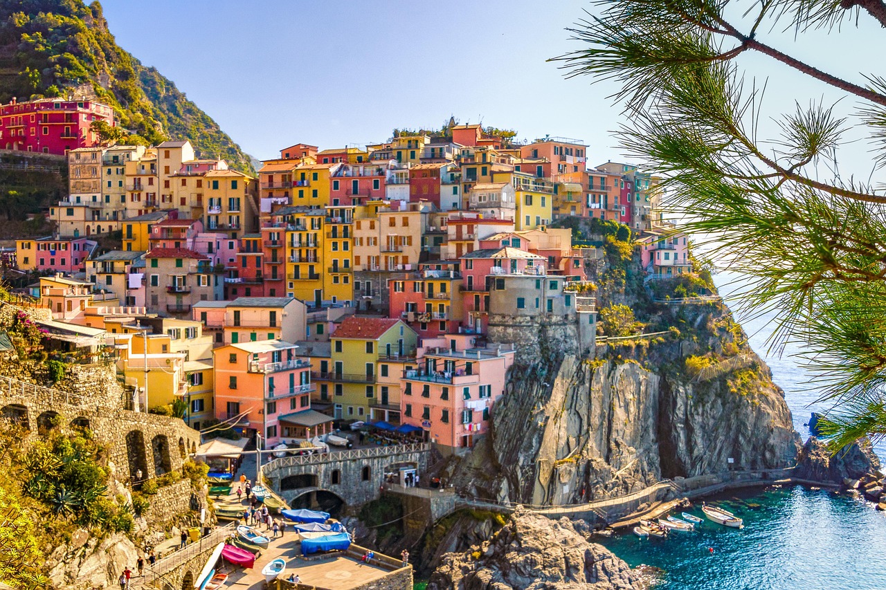 a group of boats sitting on top of a body of water, a picture, by Carlo Martini, shutterstock, fine art, cliffside town, colorful building, 4k vertical wallpaper, bulgari