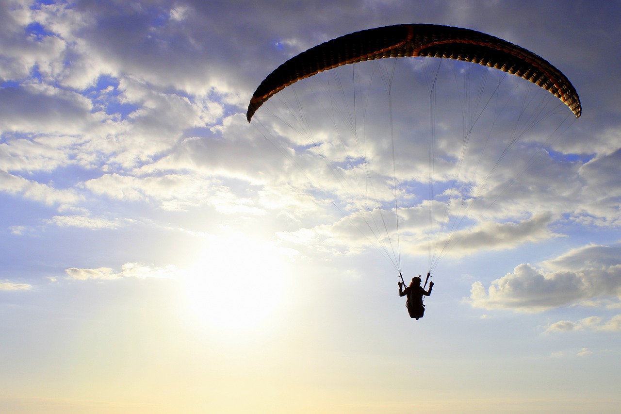 a person that is in the air with a parachute, by Niko Henrichon, shutterstock, hurufiyya, the sun up on the sky is strong, extreme panoramic, 3 4 5 3 1, karolina cummings