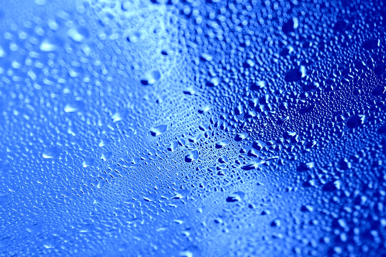 a close up of water droplets on a blue surface, a macro photograph, inspired by Yves Klein, surface with beer-texture, frosted glass, computer wallpaper, macro 8mm photo
