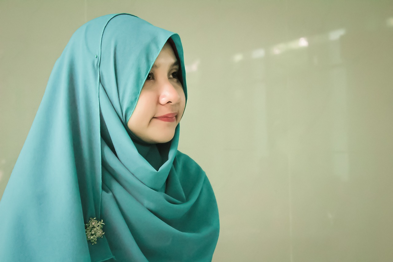 a close up of a person wearing a headscarf, a picture, inspired by Nazmi Ziya Güran, shutterstock, teal color graded, side portrait of cute girl, half body photo, happy and beautiful