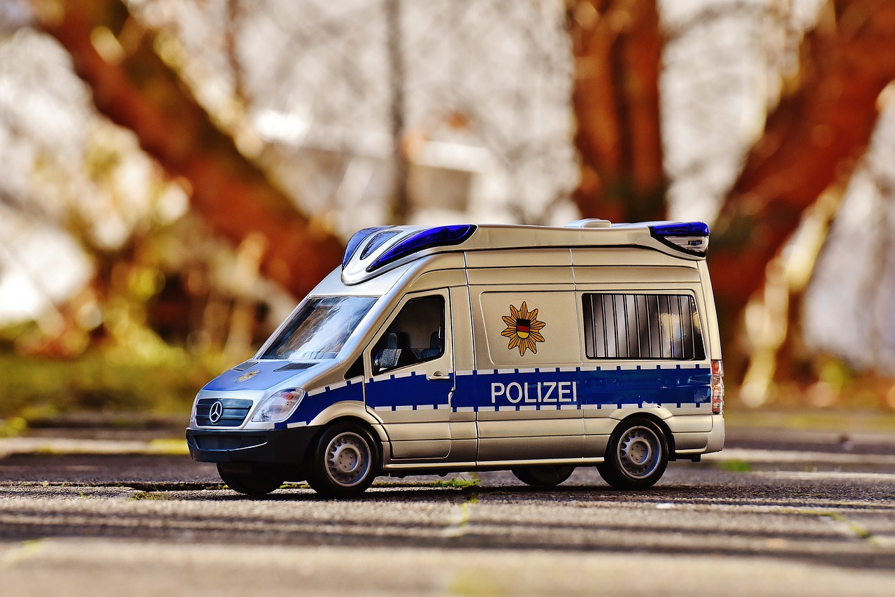 a toy police van parked on the side of the road, by Hans Schwarz, pixabay, photorealism, 🕹️ 😎 🔫 🤖 🚬, german, caravan, very very well detailed image