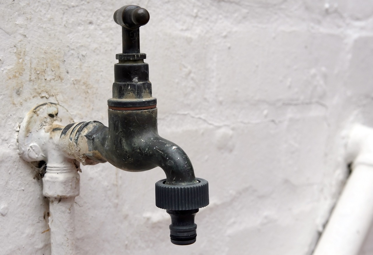 a close up of a water faucet attached to a wall, a photo, high res photo