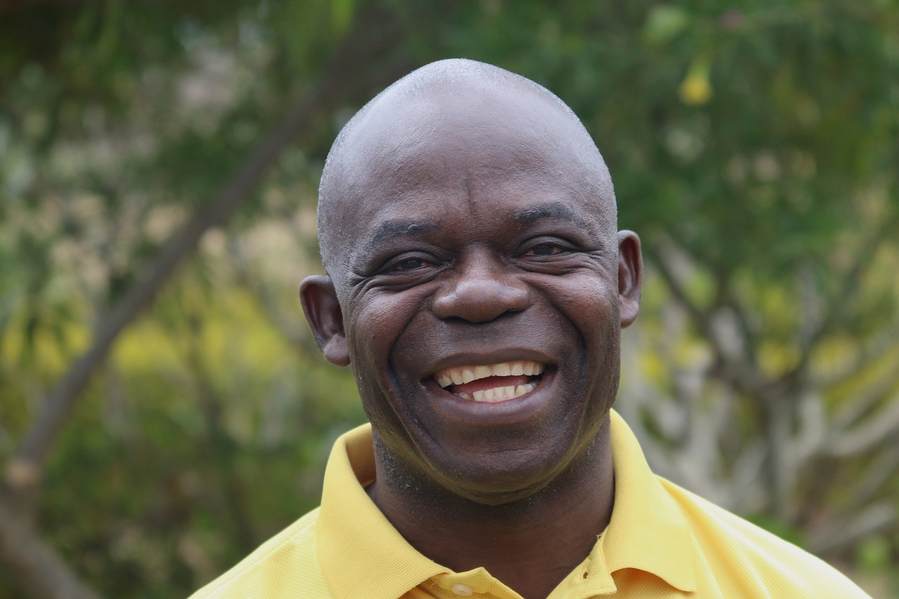 a close up of a person wearing a yellow shirt, a portrait, by Adam Manyoki, smiling man, academy headmaster, huell babineaux, professional foto