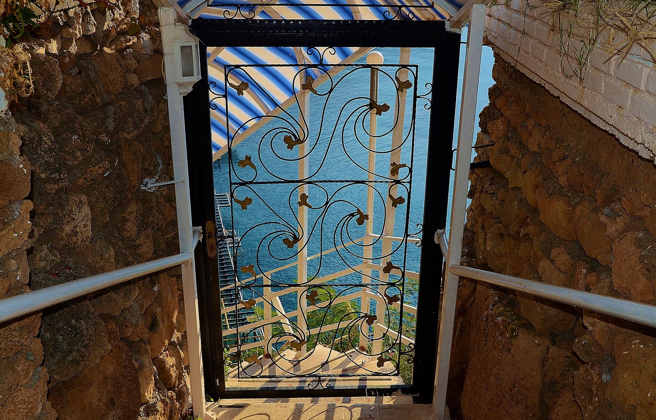 a door leading to a balcony with a view of the ocean, by Jon Coffelt, pexels, art nouveau, cell bars, israel, photo taken from above, torri gate