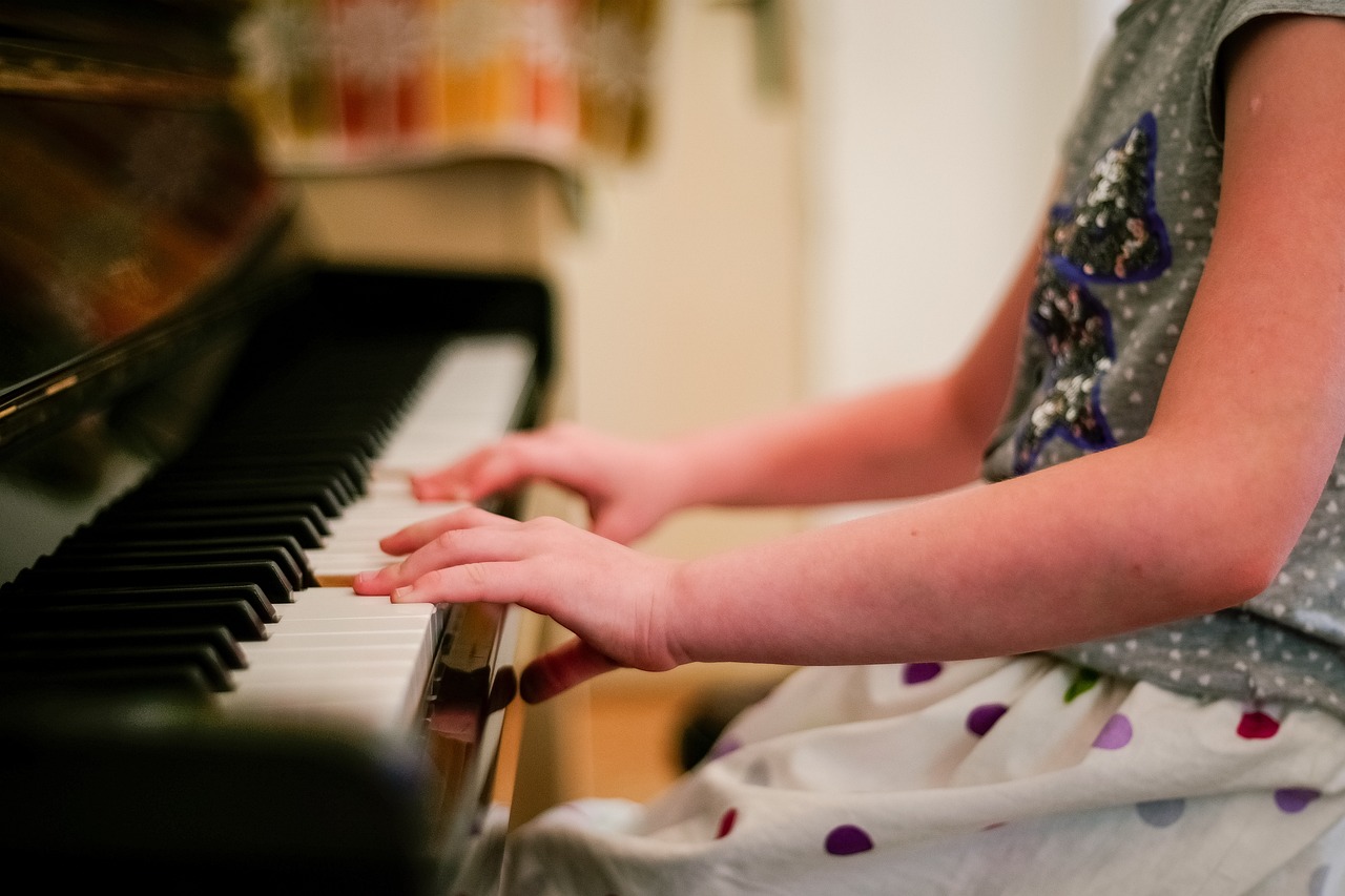 a close up of a person playing a piano, pexels, children, ornately dressed, hands reaching for her, mid shot photo