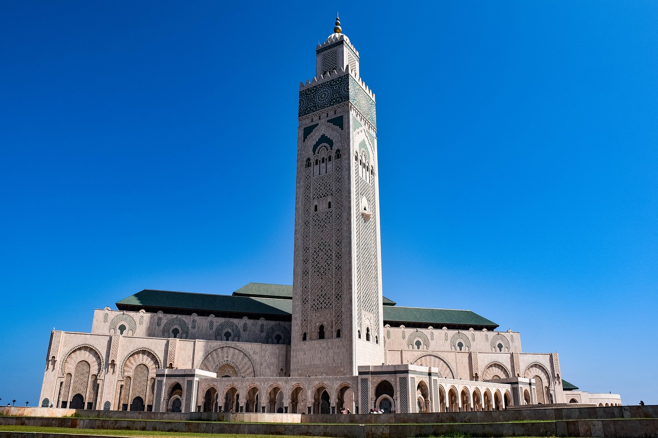 a large white building with a clock tower, inspired by Alberto Morrocco, shutterstock, hurufiyya, moroccan mosque, gigantic tower, a wide full shot, oscar winning