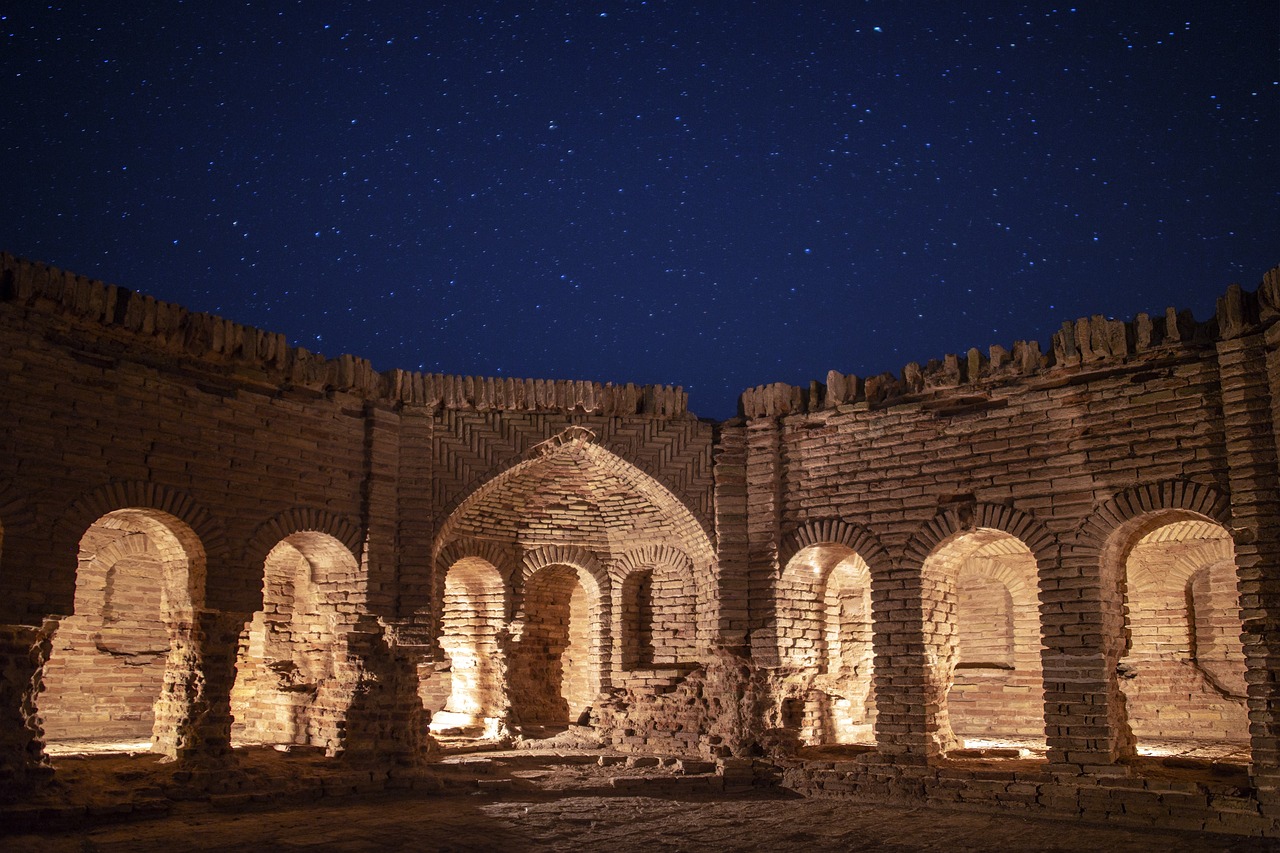 a stone building with arches and arches lit up at night, by Abdullah Gërguri, unsplash contest winner, dau-al-set, star lit sky, vereshchagin, mini amphitheatre, brick