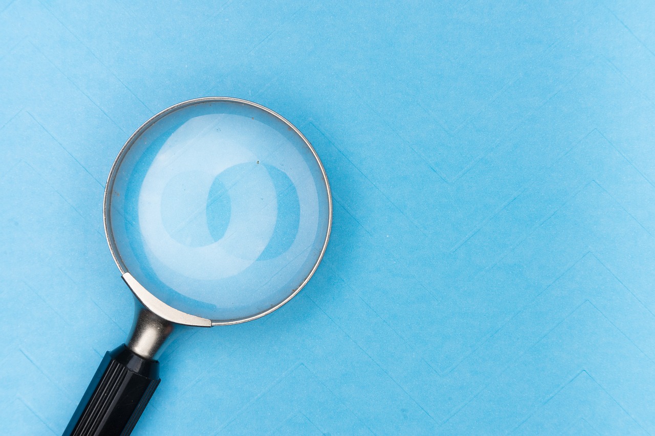 a magnifying glass on a blue surface, a stock photo, by Julian Allen, shutterstock, teal paper, birdseye view, inspect in inventory image, light blue pastel background