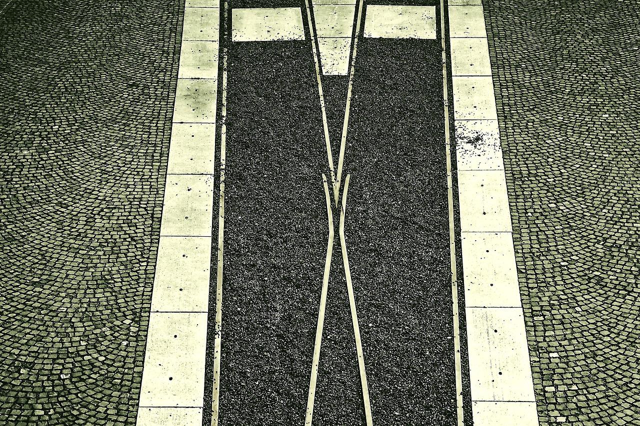 a couple of train tracks sitting next to each other, a stipple, inspired by Paul Gustav Fischer, flickr, symmetrical front view, grainy photo, crosswalks, ! low contrast!