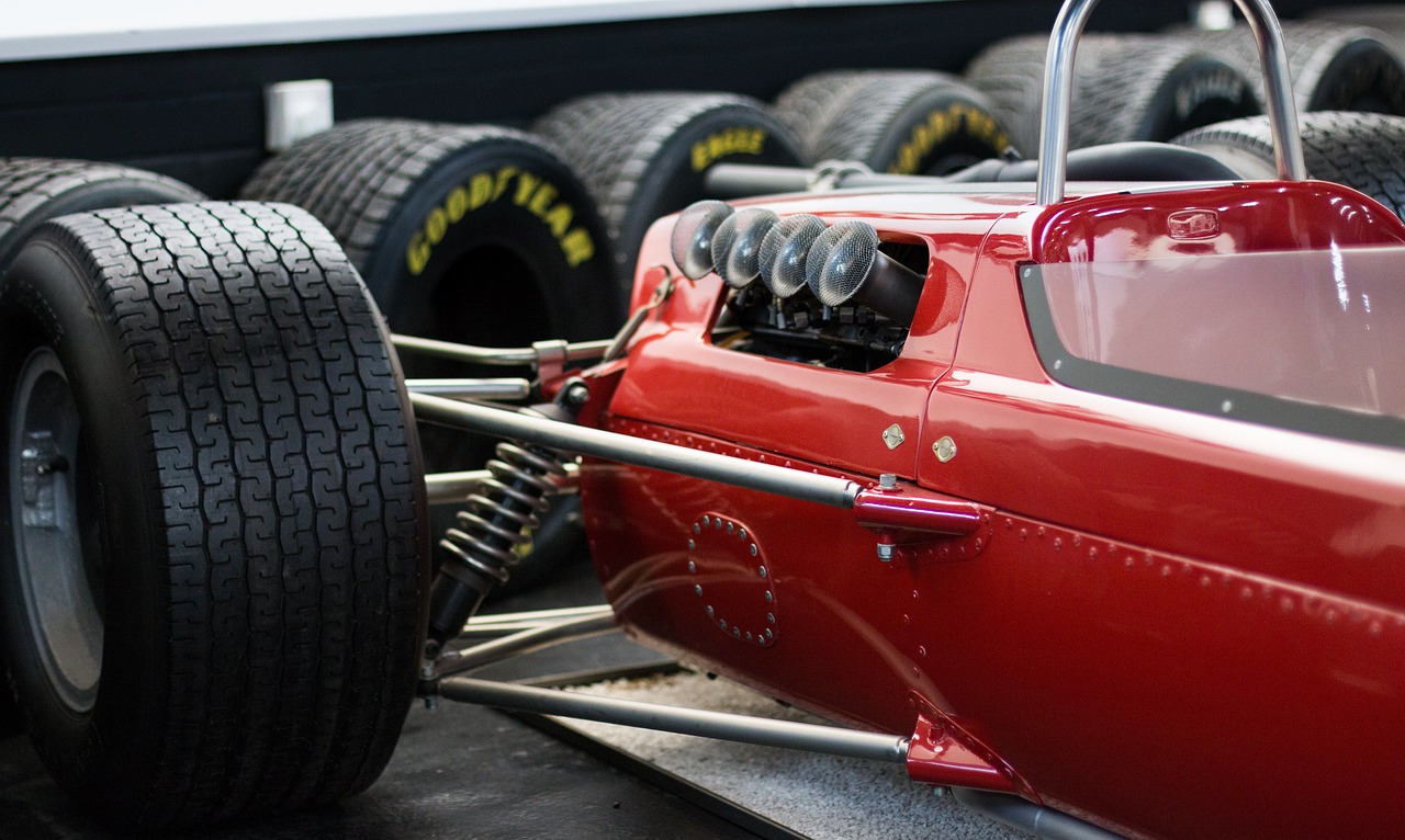 a red race car sitting on top of a pile of tires, by Etienne Delessert, flickr, incredible sharp details, f11:6, restored, levers