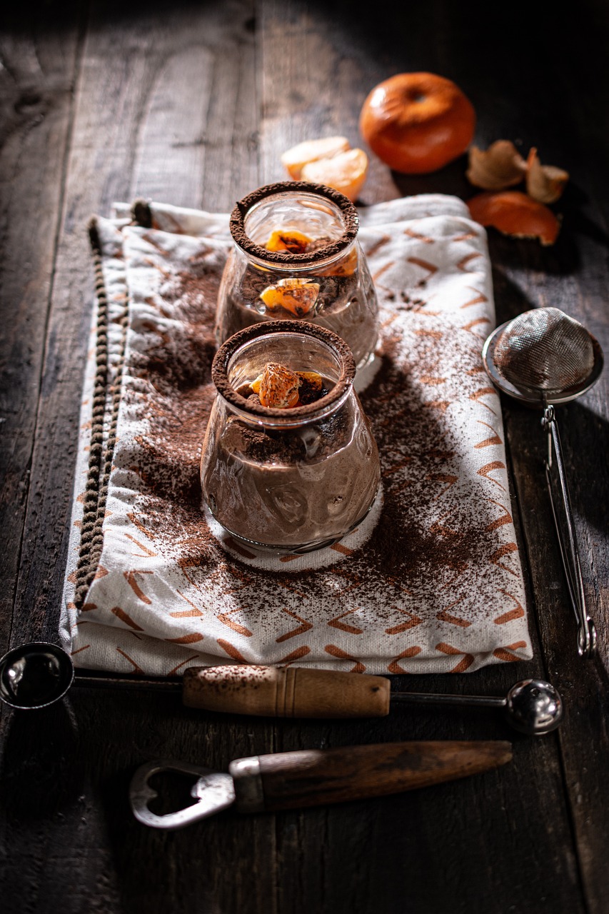 a couple of desserts sitting on top of a table, by Etienne Delessert, dark-toned product photos, hot cocoa drink, gray and orange colours, highly detailed product photo