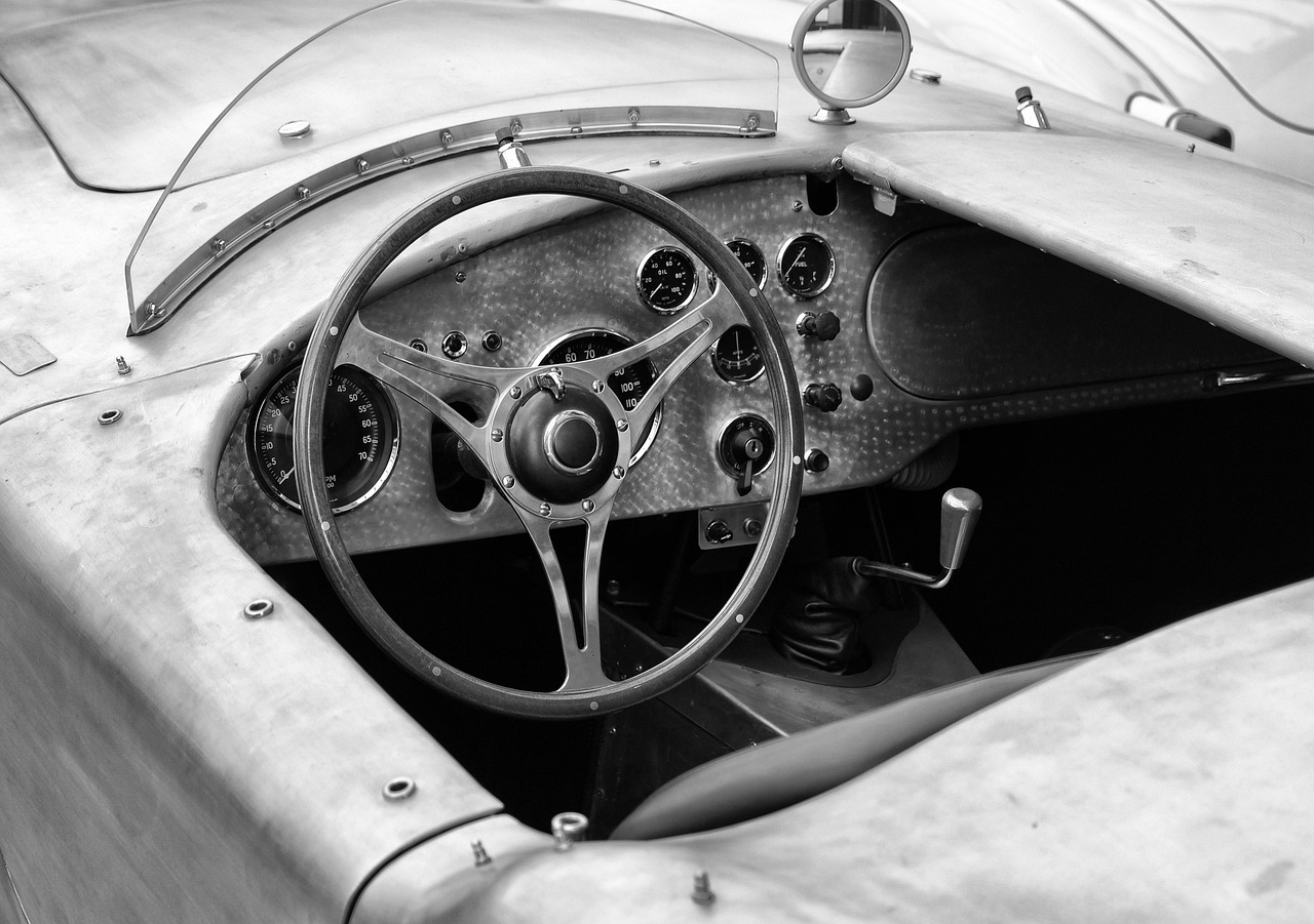 a black and white photo of a car dashboard, inspired by Harry Haenigsen, graceful curves, daytoner, a wooden, all enclosed in a circle