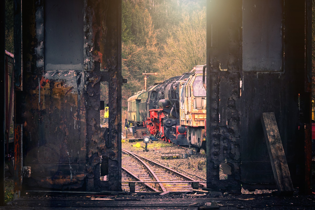 a train traveling down train tracks next to a forest, romanticism, scrapyard, big arches in the back, nostalgic atmosphere, portal