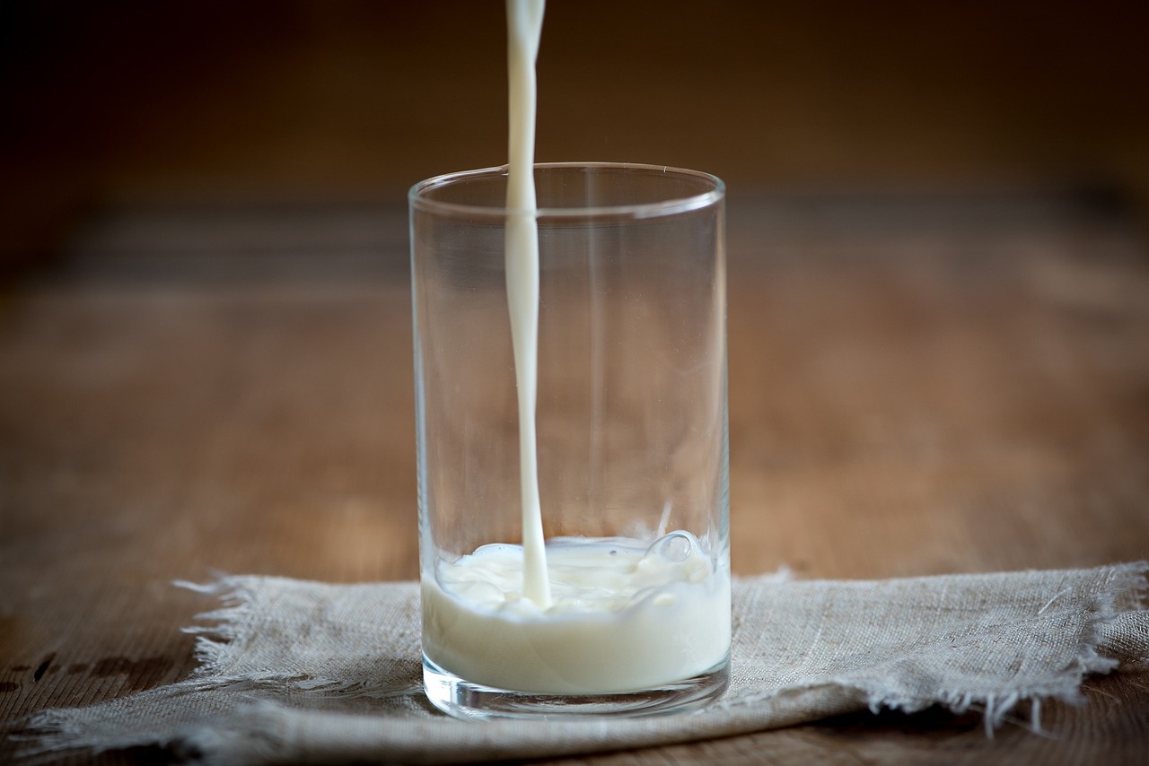 a glass filled with milk sitting on top of a table, food photography”, some pouring techniques, linen, greg rutwoski