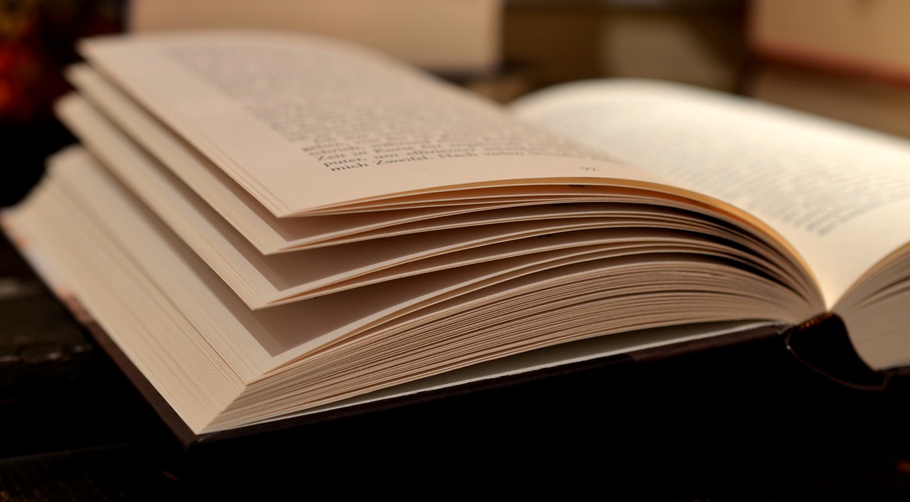 an open book sitting on top of a table, pexels, figuration libre, very closeup, version 3, vertical wallpaper, wikimedia commons