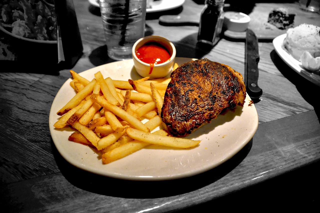 a white plate topped with a steak and french fries, a photo, by Scott M. Fischer, highly detailed saturated, rustic setting, ((oversaturated)), chicken