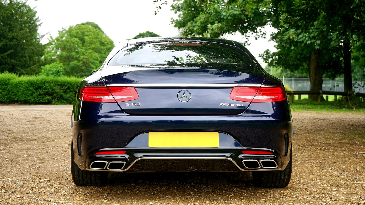 a car parked on a gravel road with trees in the background, a picture, pexels, large tail, mercedez benz, prussian blue, rear facing