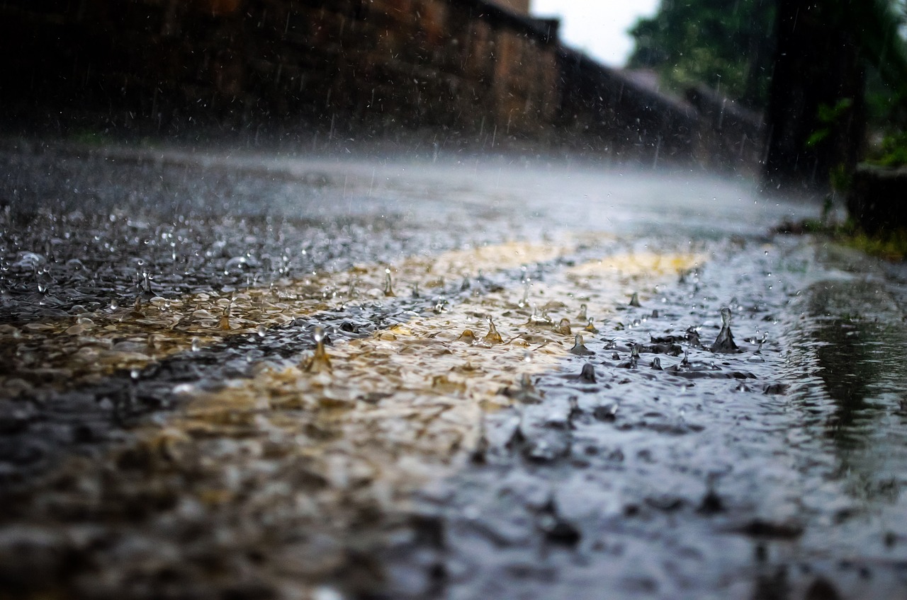 a wet street with a yellow line in the middle, a picture, by Andrew Domachowski, shallow focus background, overflowing, hd, monsoon