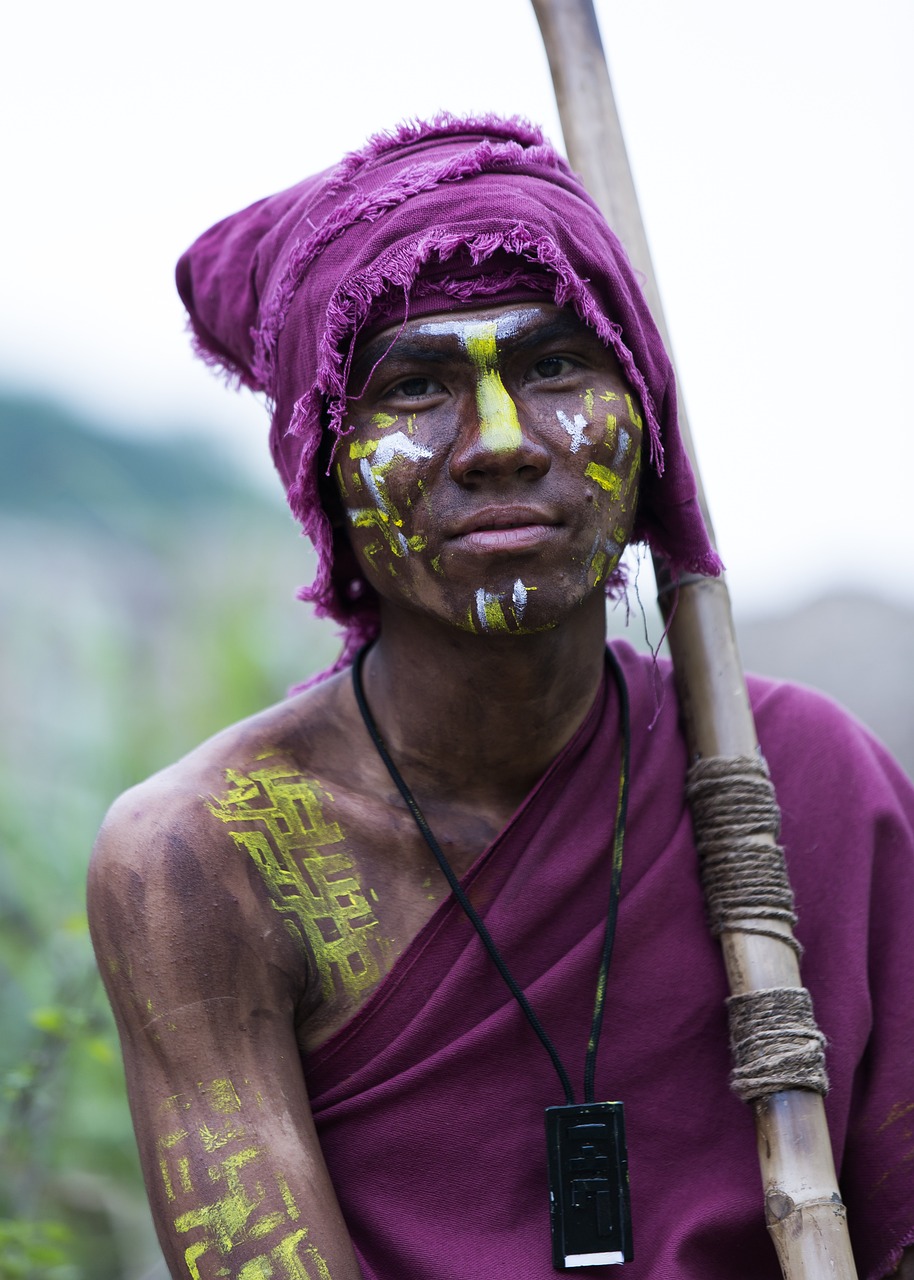 a man with yellow paint on his face holding a stick, a portrait, myanmar, professionally color graded, portrait of a female druid, happy birthday