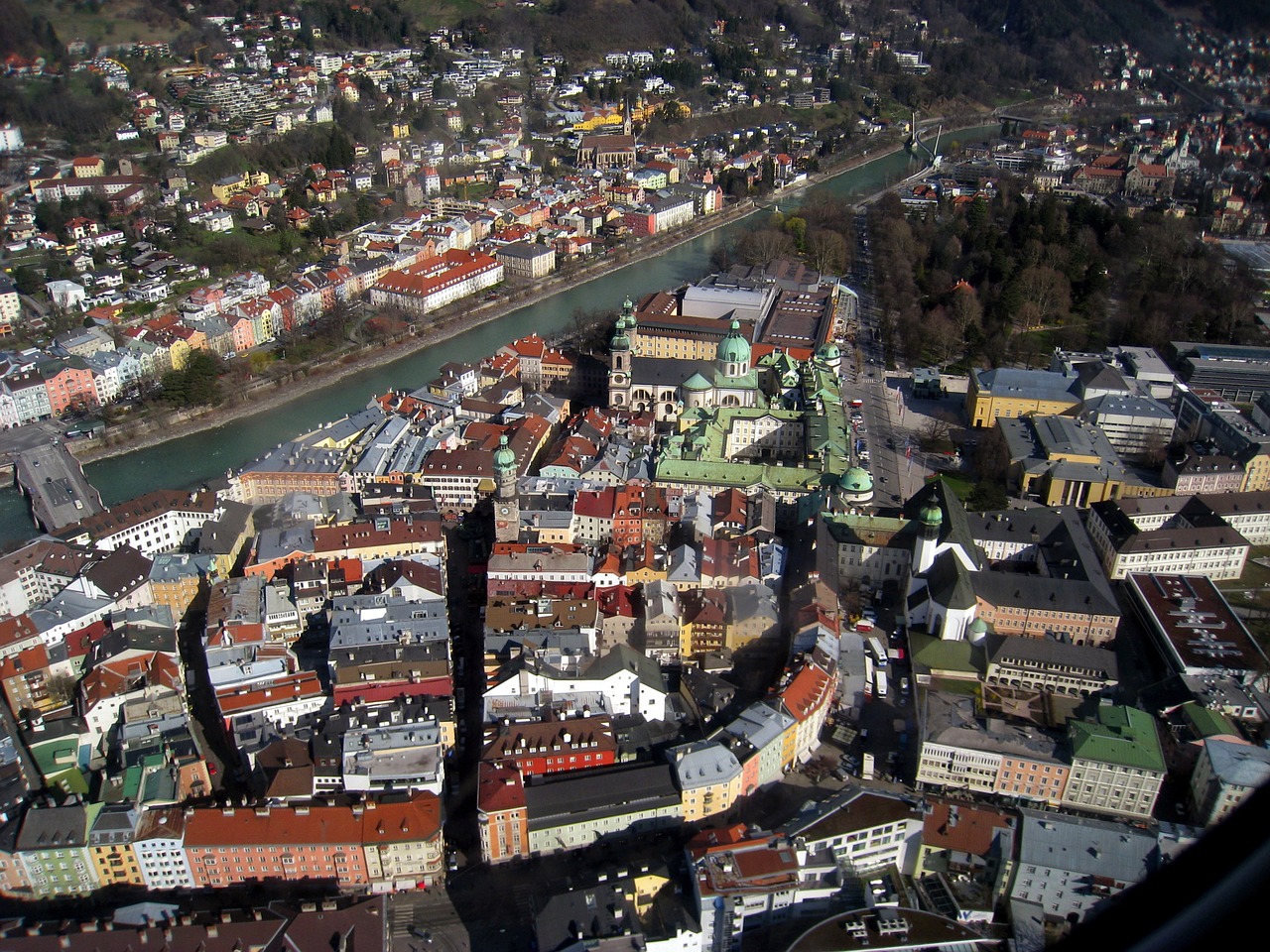 an aerial view of a city with a river running through it, viennese actionism, great light and shadows”, mountain fortress city, cathedral in the background, museum