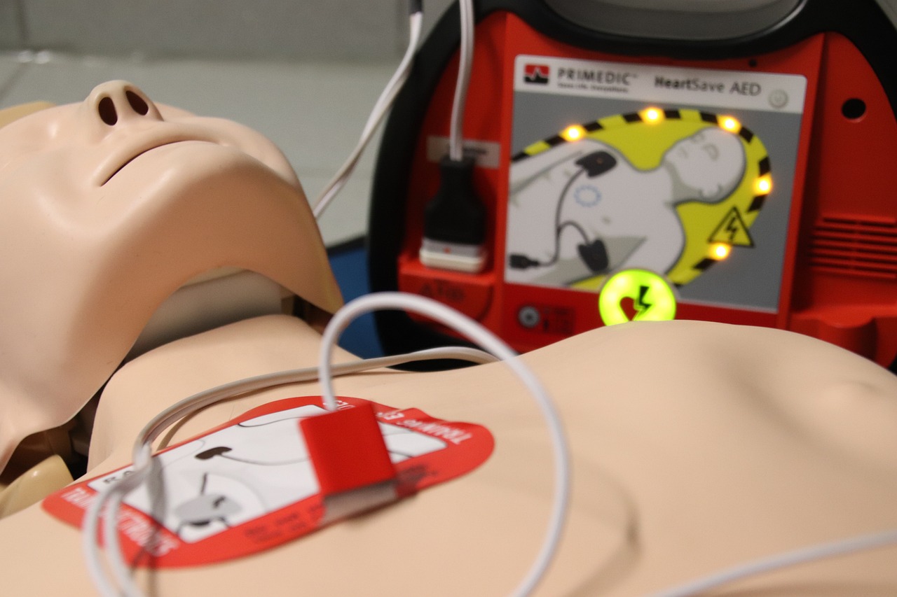 a close up of a dummy with electrodes attached to it, a picture, by Emma Andijewska, defibrillator, chest plate with ferrari logo, fluid sim, backdrop
