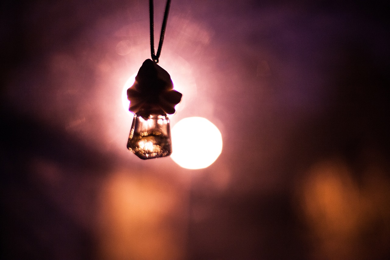 a close up of a person holding a light bulb, a picture, by Niko Henrichon, glass beads clay amulets, lensflare, taken in the night, hanging