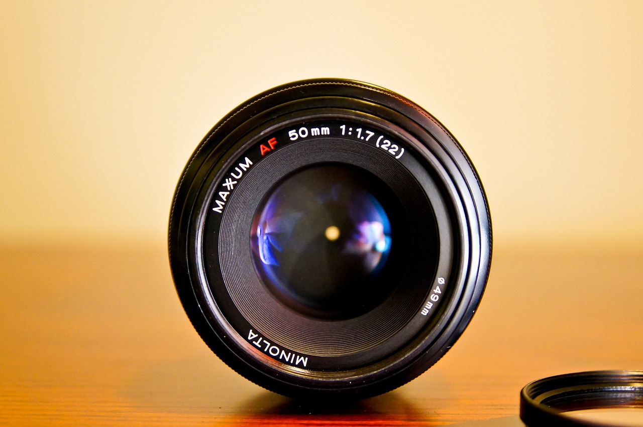 a camera lens sitting on top of a wooden table, a macro photograph, by Mathias Kollros, flickr, anon 5 0 mm, 3 5 mm!!!!!! lens, soft lens, medium wide front shot